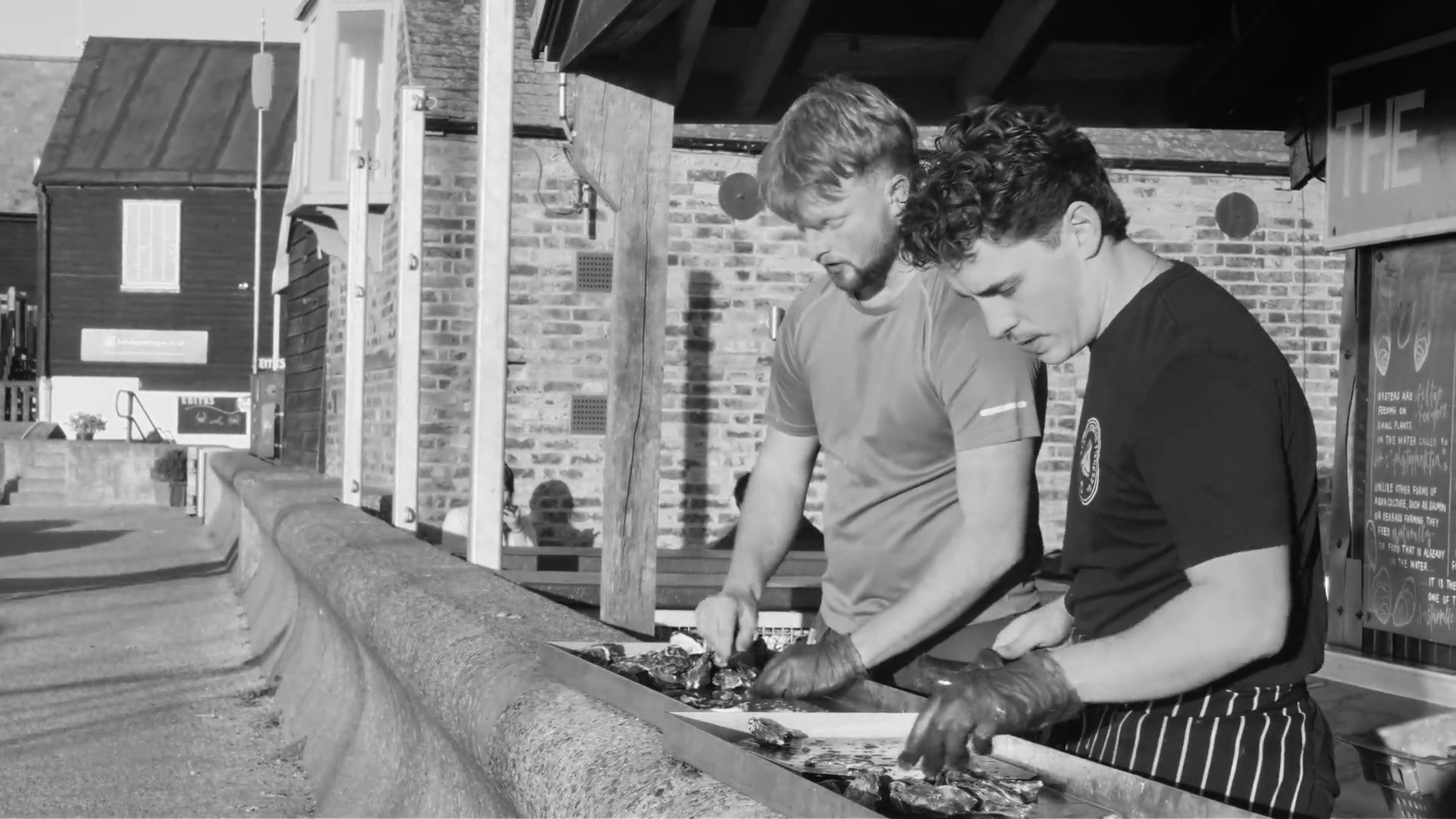 Two people preparing oysters