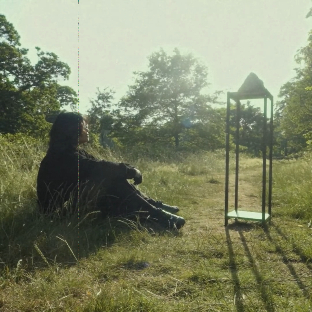 A person sitting near the stone in a park