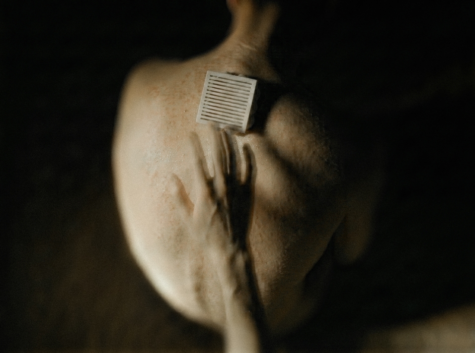 Figure holding a small object to their shoulder