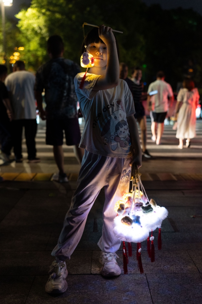 A visitor carrying a glowing rabbit lantern