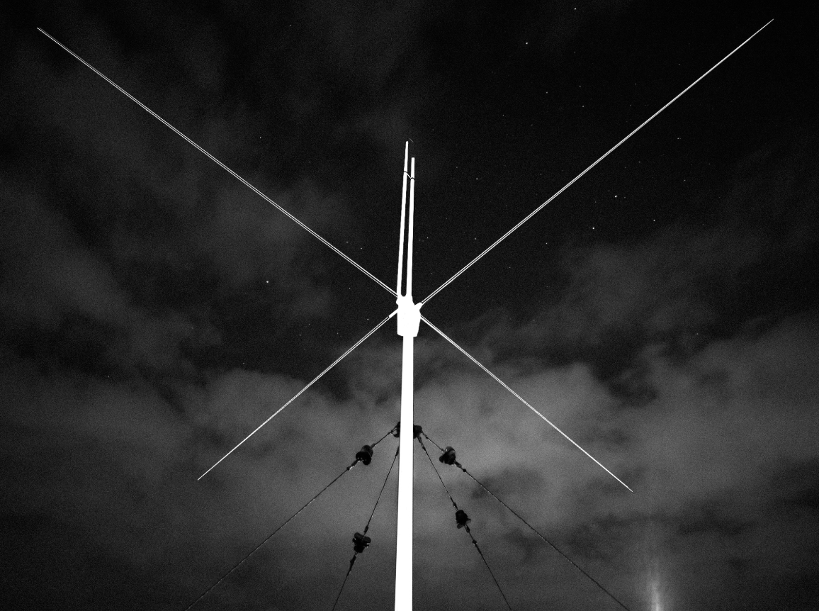Antenna silhouetted against a cloudy night sky