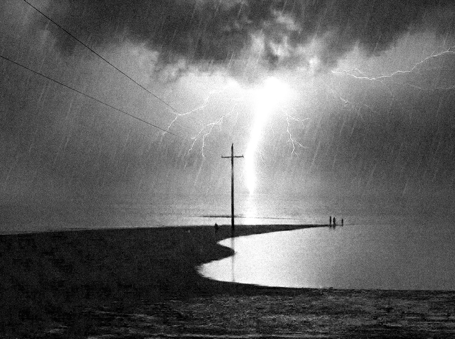 Lightning striking over a dark shoreline
