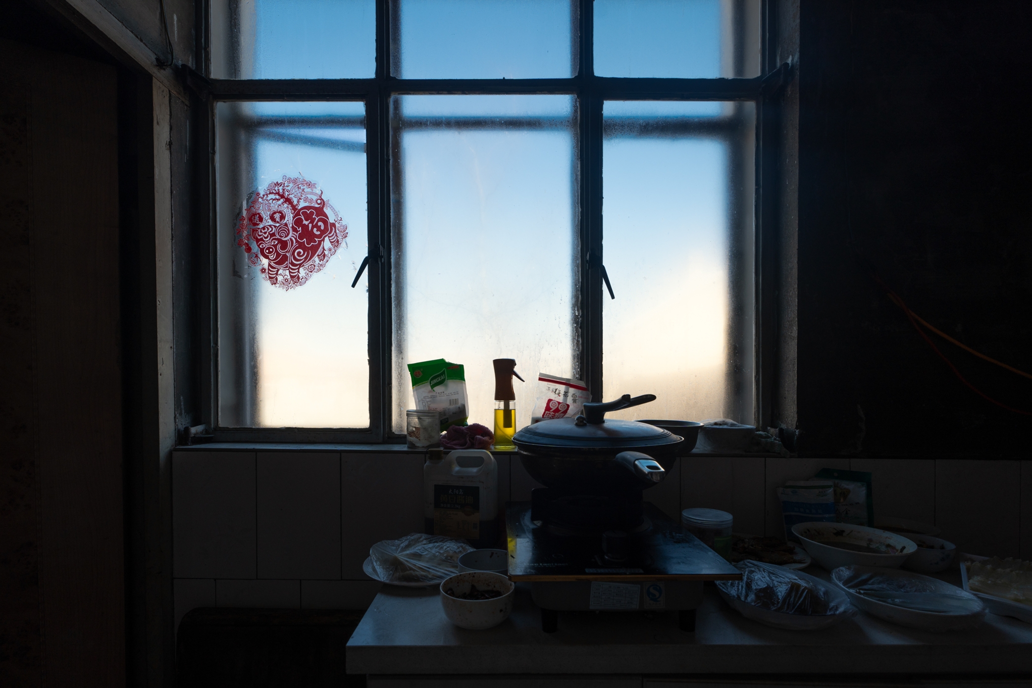A figure framed by a kitchen window