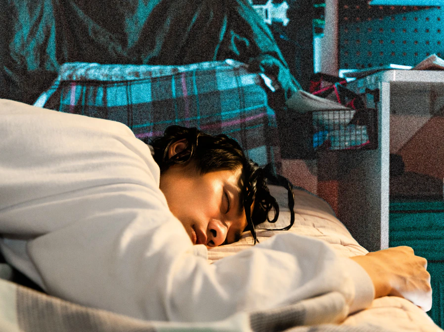 A performer resting beneath projected light
