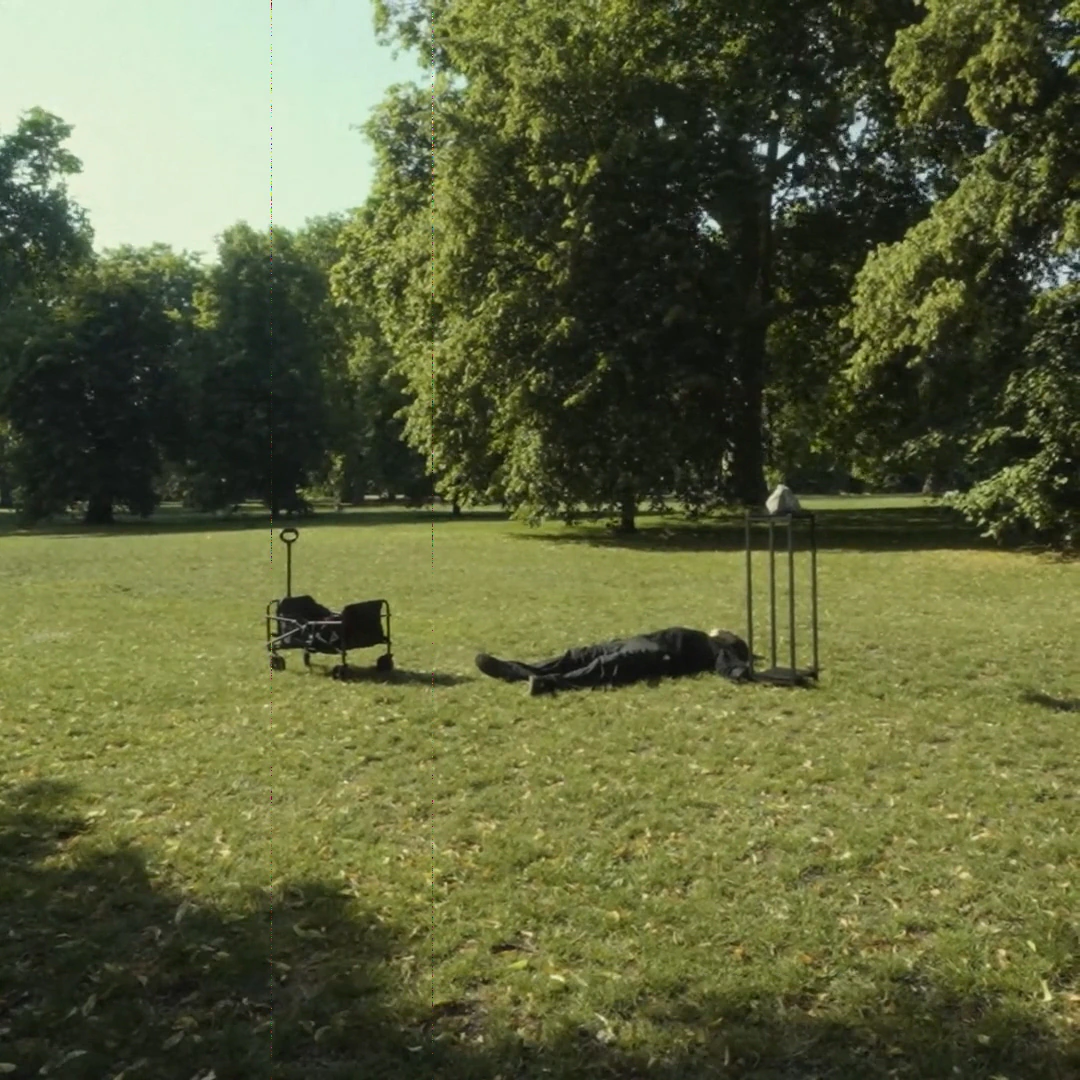 A person lying beside the stone in a park