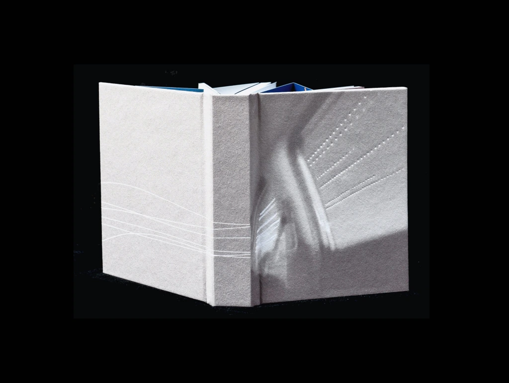 Closed artist book on a black background